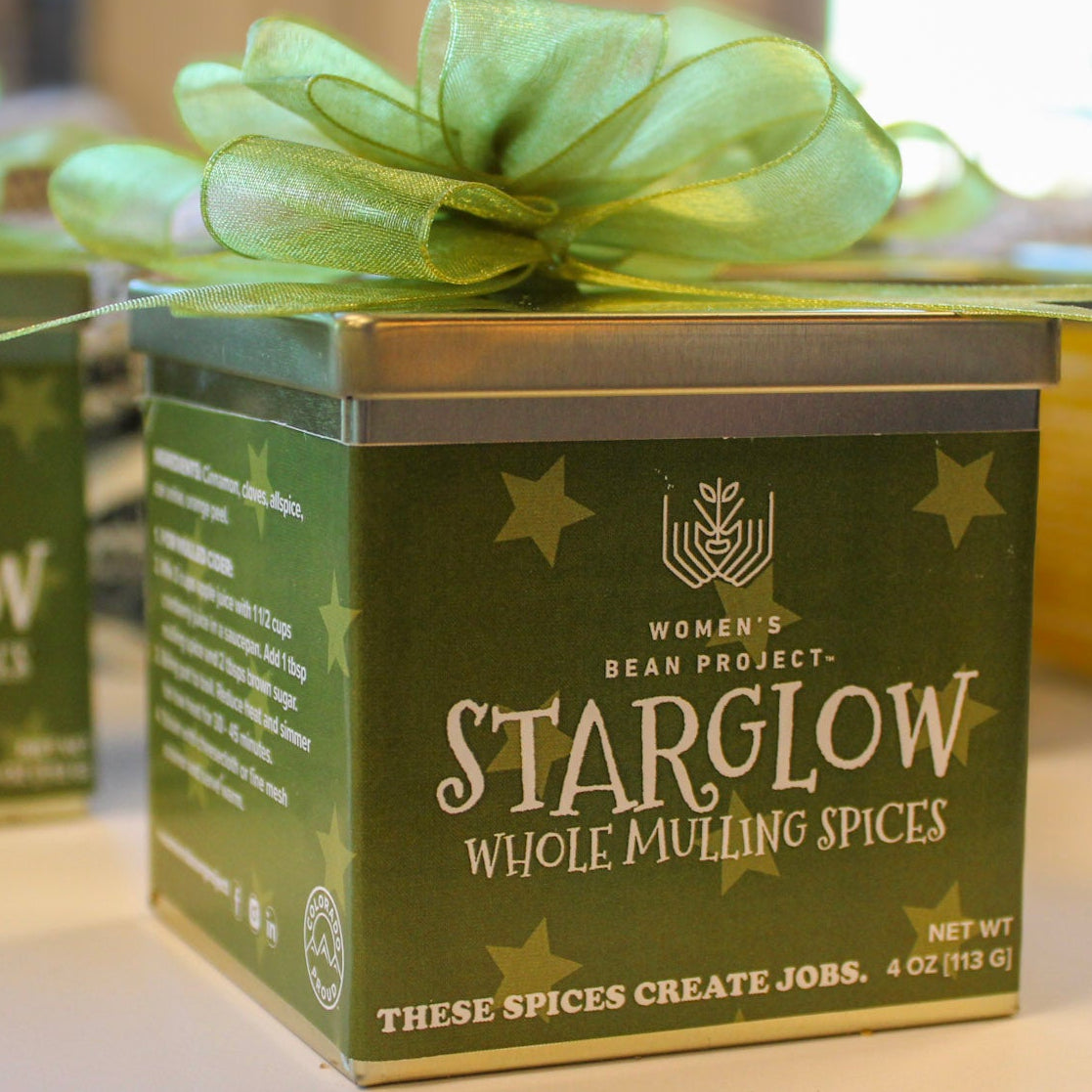 Starglow Whole Mulling Spices in a tin with a green label on a table.