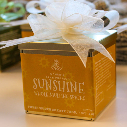 A box of Sunshine whole mulling spices with a white bow on a table.